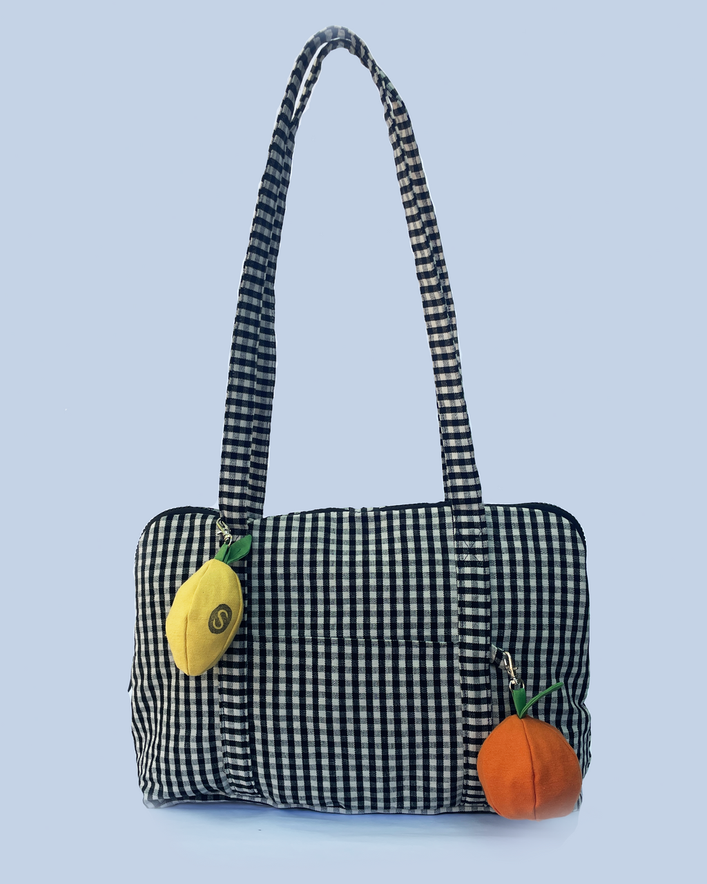 Black and white checkered handbag with lemon and orange decorations on a white background